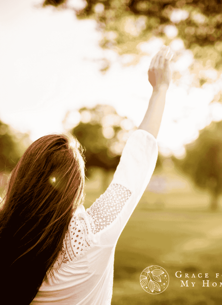 Woman lifting hands praising God outside